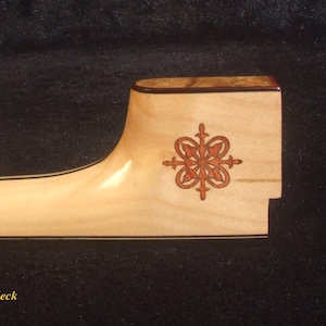 May include: A handmade tenor banjo neck with a light wood finish. The neck features a decorative inlaid design in shades of red and brown. The text "Bruce Wei Handmade Tenor Banjo Neck BN-2024" is visible.