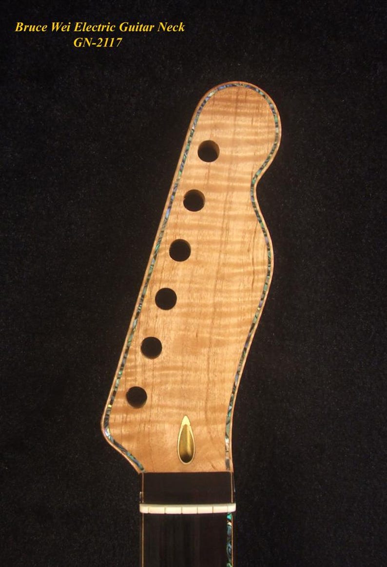 May include: Close-up of a light-colored electric guitar neck with six tuning peg holes. The neck has a decorative edge and a gold-colored accent. The text "Bruce Wei Electric Guitar Neck GN-2117" is visible.