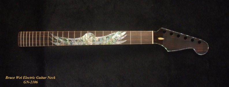 May include: A dark brown electric guitar neck with a decorative inlay of a bird in flight. The fretboard has silver frets. The headstock has six tuning peg holes. The text "Bruce Wei Electric Guitar Neck GN-2106" is at the bottom.