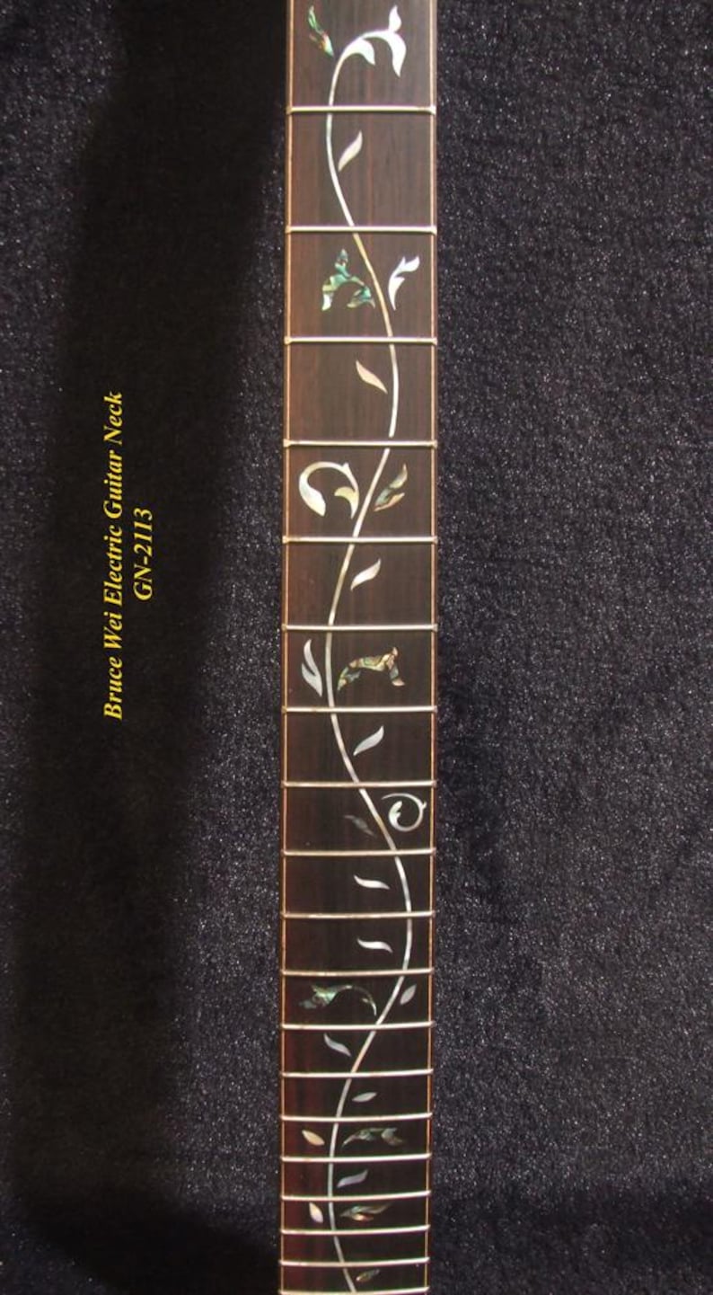 May include: Close-up of a guitar neck with a dark wood finish. The fretboard features an inlaid floral design in white and iridescent green. The text "Bruce Wei Electric Guitar Neck GN-2113" is printed on the left side.