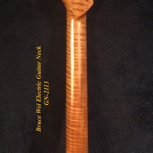 Op de afbeelding: Houten elektrische gitaarhals met een gevlamd esdoornnerfpatroon. De hals heeft een kop met zes stemgaten en een gladde, gepolijste afwerking. De tekst "Bruce Wei Electric Guitar Neck GN-2113" is zichtbaar.