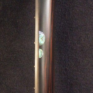 May include: Close-up of an electric guitar neck with a dark wood grain finish. The neck has two decorative inlays and the text "Bruce Wei Electric Guitar Neck GN-2113" in yellow.