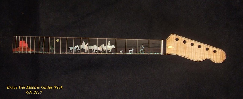 May include: Electric guitar neck with a detailed inlay depicting a Western scene. The fretboard features a red cowboy hat, riders on horseback, and desert plants. The headstock is a light wood color with tuning peg holes. The text "Bruce Wei Electric Guitar Neck GN-2117" is at the bottom.