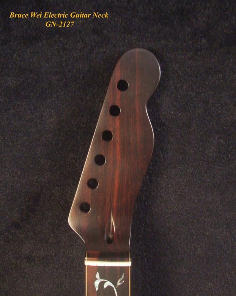 May include: A dark brown wooden electric guitar neck headstock with six circular tuning peg holes. The text Bruce Wei Electric Guitar Neck GN-2127 is visible at the top. The fretboard features a white floral inlay pattern near the nut.