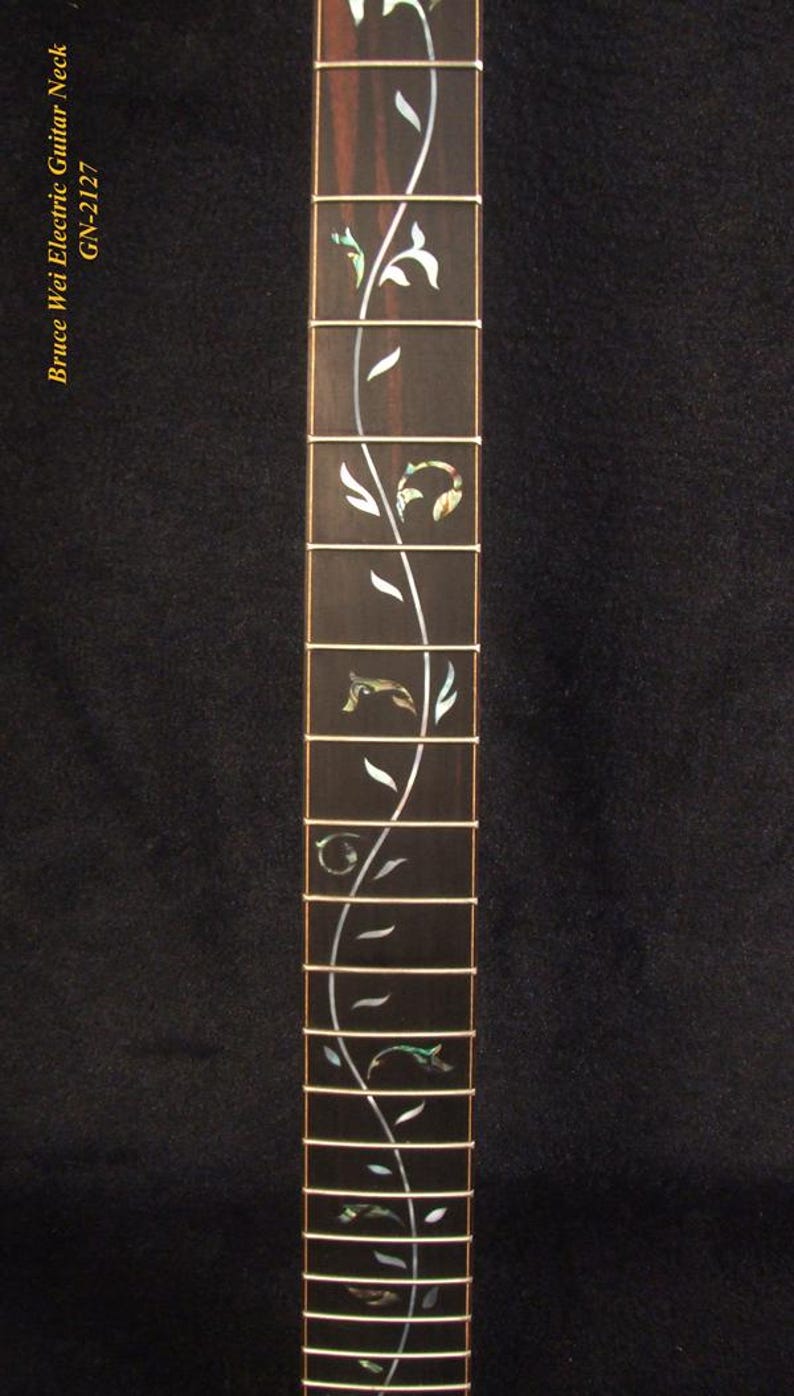 May include: An electric guitar neck with a dark wood fretboard featuring a continuous vine inlay made of iridescent abalone shell. The fretboard has silver metal frets and the text Bruce Wei Electric Guitar Neck GN-2127 is printed on the side.