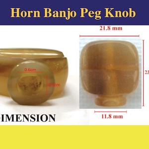 Puede incluir: Primer plano de un pomo de clavija de banjo de cuerno marrón. El pomo tiene 21,8 mm de ancho, 23,4 mm de alto y 11,8 mm de grosor. El pomo tiene un agujero en el centro de 0,6 cm de diámetro.