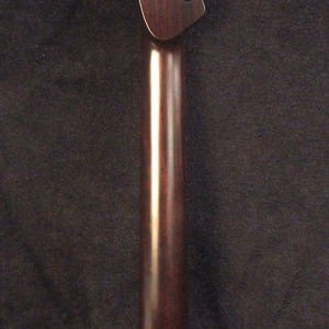 May include: A dark brown wooden electric guitar neck with a headstock featuring six tuner holes. The text Bruce Wei Electric Guitar Neck GN-2127 is printed vertically along the left side. A small rectangular label is visible at the base.