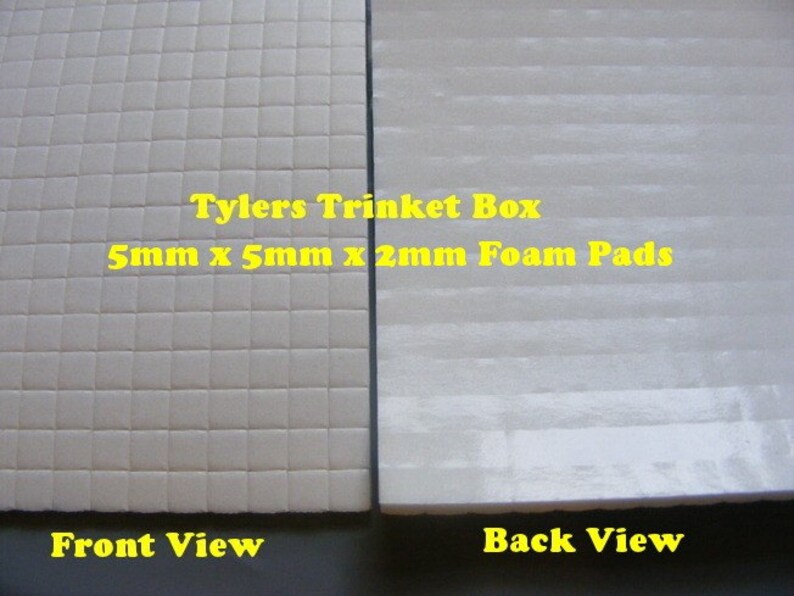 May include: Two views of a white foam pad. The front view shows a grid pattern of small squares. The back view shows a smooth surface with horizontal lines. The text "Tylers Trinket Box 5mm x 5mm x 2mm Foam Pads" is printed on the foam pad.