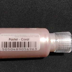 Puede incluir: Una peque&ntilde;a botella de pintura de color coral con un gotero transparente. La etiqueta dice "Pastel - Coral" y tiene un c&oacute;digo de barras con el n&uacute;mero 5050489056963.