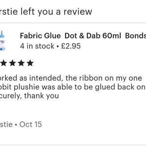 May include: A five-star review for Fabric Glue Dot & Dab 60ml Bonds, a product that comes in a blue bottle with a white label. The review states that the glue worked as intended and was able to securely glue a ribbon back onto a rabbit plushie. The review was left by Kirstie on October 15th.
