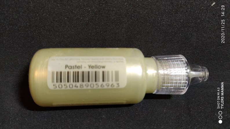 Puede incluir: Una peque&ntilde;a botella de pintura amarilla pastel con un gotero transparente. La etiqueta dice "Pastel - Amarillo" y tiene un c&oacute;digo de barras con el n&uacute;mero 5050489056963.