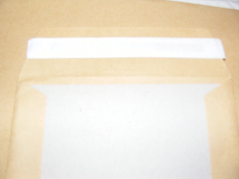 K&ouml;nnte beinhalten: Ein brauner Papierumschlag mit einem wei&szlig;en Streifen oben.