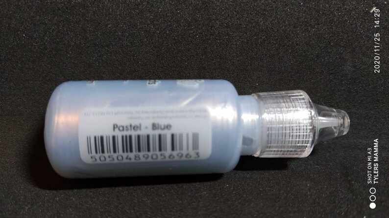 Puede incluir: Una peque&ntilde;a botella de pintura azul con una punta aplicadora de pl&aacute;stico transparente. La etiqueta dice "Pastel - Azul" y tiene un c&oacute;digo de barras con el n&uacute;mero 5050489056963.