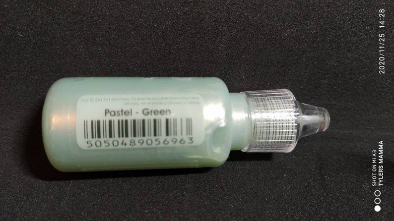 Puede incluir: Una peque&ntilde;a botella transparente con un l&iacute;quido verde en su interior. La botella tiene una etiqueta que dice "Pastel - Green" y un c&oacute;digo de barras con el n&uacute;mero 5050489056963.
