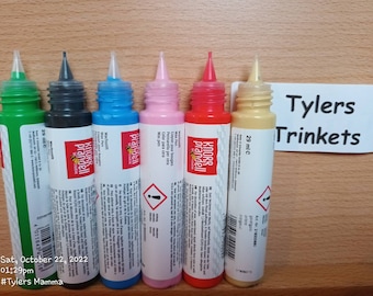May include: Six bottles of wax paint in various colours, including green, black, blue, pink, red, and yellow. Each bottle is labelled with the brand name "Knorr Prandell" and the text "29 ml". The bottles are arranged in a row on a wooden surface. The text "Tylers Trinkets" is visible in the background.
