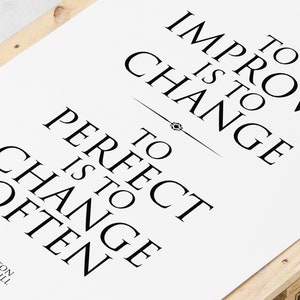 May include: Black and white typography print with the quote "To improve is to change, to perfect is to change often." attributed to Winston Churchill.