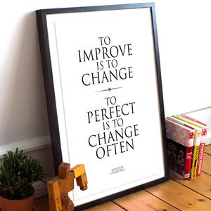 May include: Black and white framed print with a quote by Winston Churchill: "To improve is to change. To perfect is to change often."