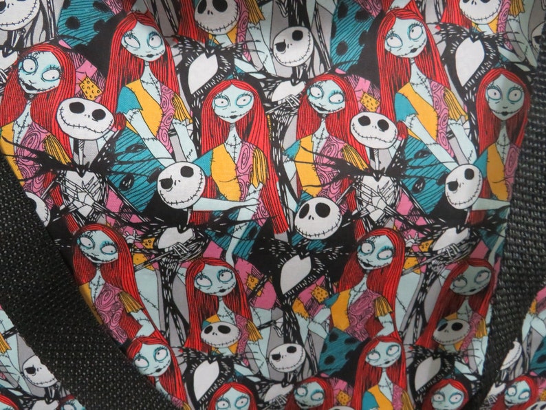 May include: A black and white fabric with a repeating pattern of Jack Skellington and Sally from the Nightmare Before Christmas. The characters are in various poses and expressions, with Sally's red hair and Jack's white face and black suit clearly visible.