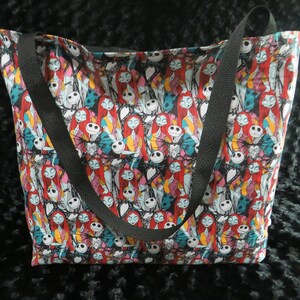 May include: A black tote bag with a colorful print of Jack Skellington and Sally from the Nightmare Before Christmas.