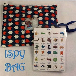 May include: A blue and red fabric bag with a clear plastic window. The bag is labelled "I Spy Bag". A white card with the words "iSPY" is attached to the bag. The card lists 60 items to find, such as a sword, boot, squirrel, fortune cookie, ice cream, dragon, heart, Q, football, pig, fly, acorn, turtle, fish, bottle, marshmallow, fire truck, button, soldier, shoe, moustache, bear, gear, and anchor.
