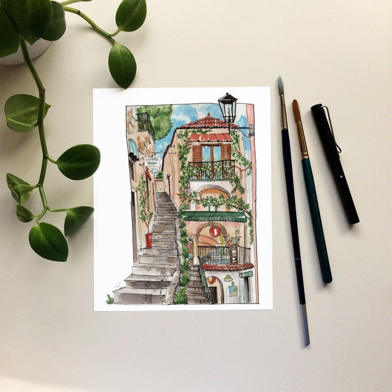 May include: Watercolor painting of a building with a red roof and a green awning. The building has a balcony with a wrought iron railing and a window with a view of the street below. The building is located on a hill and there are stairs leading up to it. The painting is done in a realistic style and the colors are bright and vibrant.