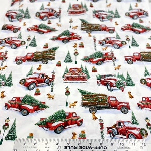 K&ouml;nnte beinhalten: Wei&szlig;er Stoff mit einem sich wiederholenden Muster aus roten Oldtimern, die Weihnachtsb&auml;ume, Schnee und kleine braune Hunde transportieren. Gr&uuml;ne Weihnachtsb&auml;ume und Stra&szlig;enlaternen sind ebenfalls abgebildet. Das Muster ist etwa 30 cm breit.