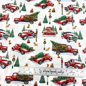 K&ouml;nnte beinhalten: Wei&szlig;er Stoff mit einem sich wiederholenden Muster aus roten Oldtimer-Trucks, die Weihnachtsb&auml;ume, Geschenke und kleine braune Hunde transportieren. Gr&uuml;ne Weihnachtsb&auml;ume und Stra&szlig;enlaternen sind ebenfalls abgebildet.