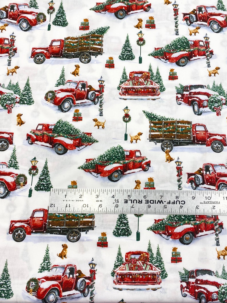 K&ouml;nnte beinhalten: Wiederholendes Muster auf wei&szlig;em Stoff mit roten Oldtimer-Trucks, die Weihnachtsb&auml;ume und Geschenke transportieren. Kleine braune Hunde und gr&uuml;ne Weihnachtsb&auml;ume sind &uuml;ber das Design verstreut. Schnee bedeckt den Boden und die Trucks.
