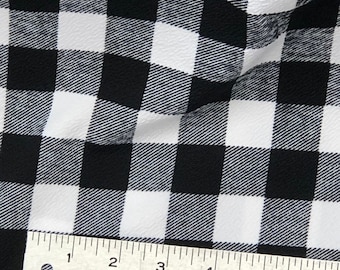 May include: Black and white checkered fabric with a ruler measuring 6 inches. The fabric has a textured surface.