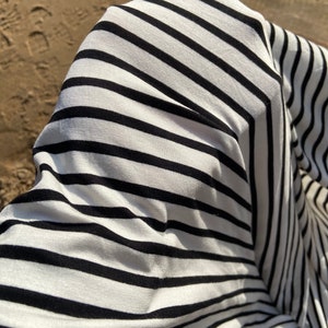 May include: Close-up of a white and black striped fabric with a textured surface.