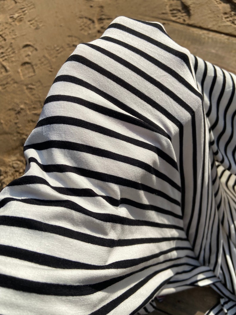 May include: Close-up of a white and black striped fabric with a textured surface.