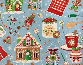 May include: Light blue fabric with a Christmas theme. The pattern includes gingerbread houses, gingerbread people, candy canes, lollipops, and a jar labeled "Cookies for Santa." Other elements include a red oven mitt and a cup of hot cocoa.
