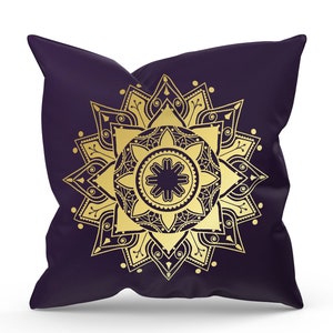 May include: A purple pillow with a gold mandala design. The mandala is intricate and detailed, with a central flower and radiating patterns.