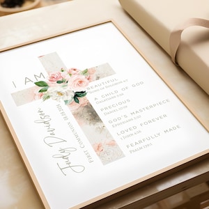 May include: A watercolor painting of a cross with pink flowers and gold accents. The text "I AM" is at the top of the cross, and the text "Judy Davidson" is on the left side of the cross. The text "FIRST COMMUNION 08.09.2024" is on the left side of the cross. The text "BEAUTIFUL SONG OF SOLOMON 4:7" is on the right side of the cross. The text "A CHILD OF GOD GALATIANS 3:26" is on the right side of the cross. The text "PRECIOUS DANIEL 10:19" is on the right side of the cross. The text "GOD'S MASTERPIECE EPHESIANS 2:10" is on the right side of the cross. The text "LOVED FOREVER 1 JOHN 4:16" is on the right side of the cross. The text "FEARFULLY MADE PSALM 139:1" is on the right side of the cross.