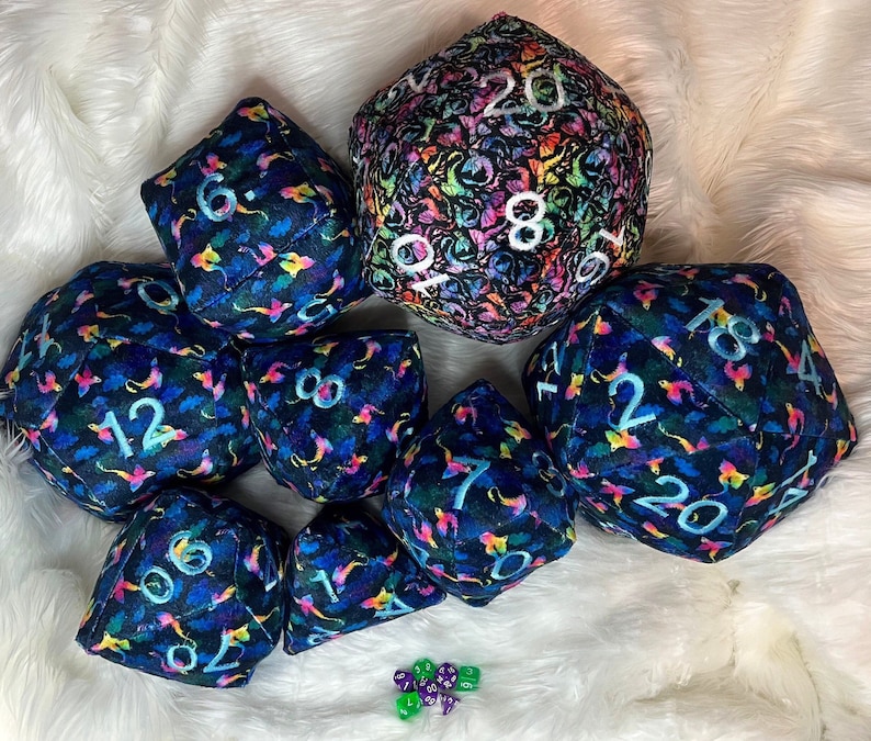 May include: A set of nine plush dice with a dark blue background and colorful floral patterns. The dice are numbered 1 through 20.