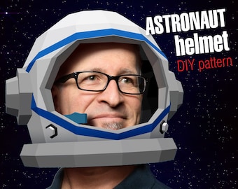May include: A person wearing a white and blue astronaut helmet against a black starry background. The text "ASTRONAUT helmet DIY pattern" is in red and white lettering.