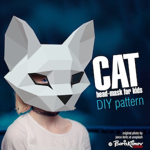 May include: A white paper cat head mask for kids. The mask is a DIY pattern and has a blue eye. The text on the image reads "CAT head-mask for kids DIY pattern".