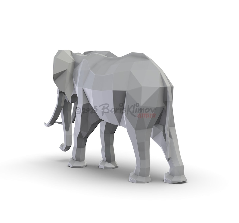 May include: A gray, geometric elephant sculpture, viewed from the rear, stands on a white surface. The sculpture is made of many flat, triangular planes. The artist's name and copyright are visible on the side of the elephant.