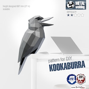 May include: A geometric, grey kookaburra sculpture, designed for DIY metal welding. The bird is approximately 68.7 cm tall and is scalable. The image includes the text "pattern for DIY KOOKABURRA", and icons for PDF and DXF downloads.