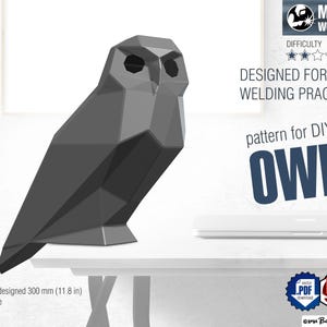 Op de afbeelding: Een donkergrijze geometrische uilsculptuur ontworpen voor lasoefeningen. De afbeelding bevat tekst: METAL WELDING, DESIGNED FOR WELDING PRACTICE, pattern for DIY OWL, en height designed 300 mm (11.8 in) scalable, met PDF- en DXF-downloadpictogrammen.