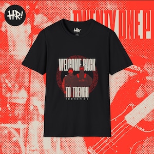 Puede incluir: Camiseta negra con el texto "WELCOME BACK TO TRENCH" en blanco y rojo. La camiseta presenta un gráfico de dos personas frente a un círculo rojo. El logotipo de Twenty One Pilots está en la parte inferior.