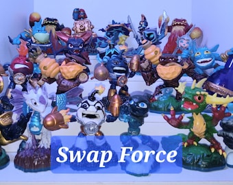 May include: A collection of Swap Force Skylanders figures, including a gold gorilla, a blue and green dragon, a green and yellow dragon, a blue and green creature with wings, and a blue and green creature with a bottle. The figures are arranged on a shelf with the text "Swap Force" in blue letters.