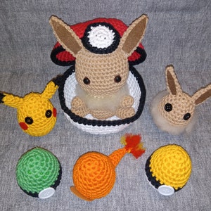 May include: Crocheted Pokemon plushies, including Eevee, Pikachu, Charmander, and Squirtle. The Eevee plushie is in a crocheted Pokeball.