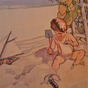 Pode incluir: Uma criança pequena sentada em uma praia de areia, segurando uma pá rosa e vermelha. A criança está vestindo uma camiseta branca sem mangas e shorts amarelos. Um veleiro está no fundo.