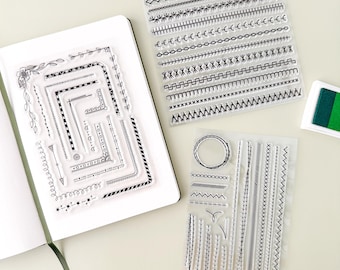 May include: Two clear acrylic stamp sheets with various border designs. The first sheet features a variety of corner and border designs. The second sheet features a variety of lines, zigzags, and a circle.