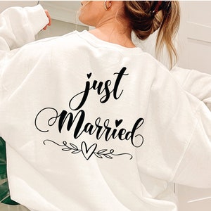 May include: White sweatshirt with the text "just married" in black cursive lettering with a small heart design.