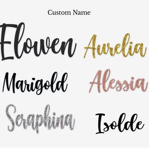 May include: A display of custom names in various fonts and finishes. The names Elowen, Marigold, and Isolde are in solid black. The names Aurelia, Alessia, and Seraphina feature gold, rose gold, and silver glitter textures respectively.