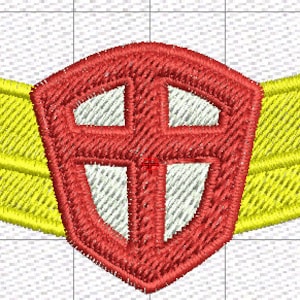 Puede incluir: Un parche bordado que presenta un escudo rojo central con un diseño de cruz blanca, flanqueado por dos alas amarillas simétricas. El diseño está realizado con un patrón de puntadas densas sobre un fondo de cuadrícula claro.