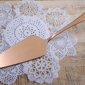 a gold serving spoon on a white doily