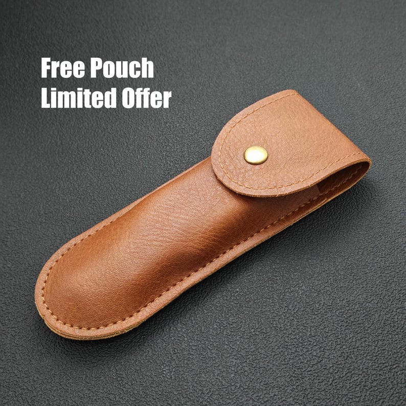 A leather pouch with a gold button, placed on a dark surface.